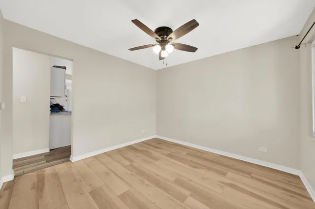 an empty room with window and ceiling fan
