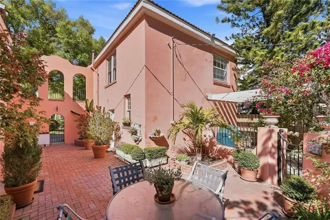 a view of a patio with couches table and chairs and potted plants
