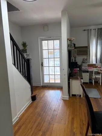 a view of a hallway with wooden floor and staircase