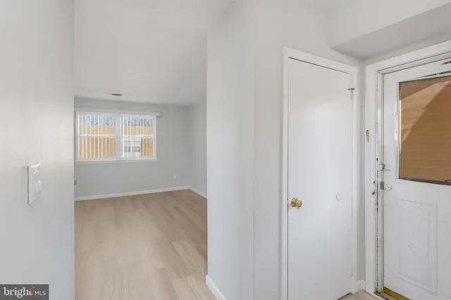 a view of an empty room with window and closet area