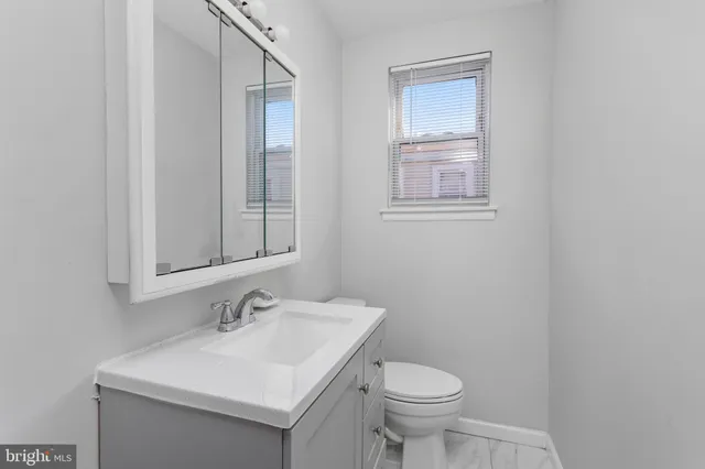 a bathroom with a sink toilet and a mirror