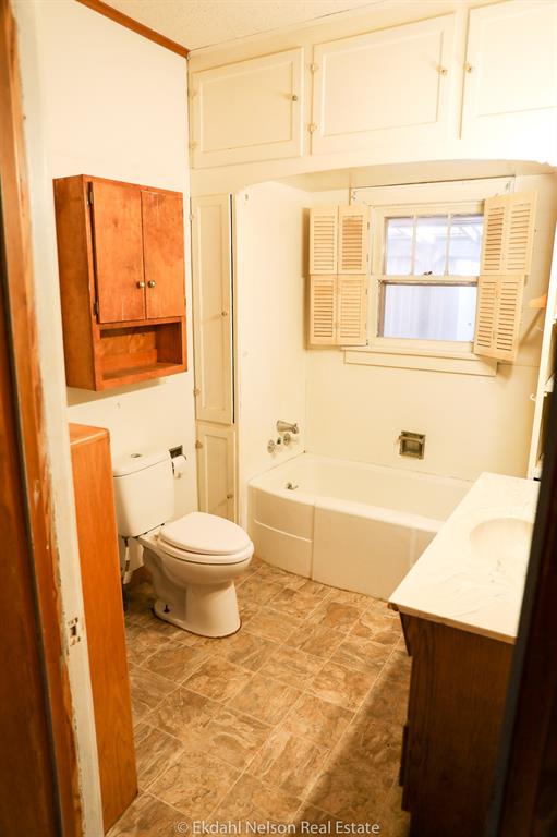 411 North McKinley Avenue Rotan, TX 79546 - Photo 18 of 25 a bathroom with a toilet a sink and a bathtub