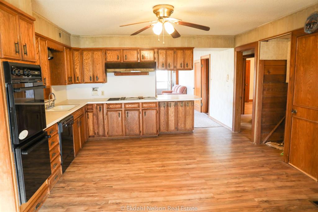411 North McKinley Avenue Rotan, TX 79546 - Photo 22 of 25 a kitchen with stainless steel appliances granite countertop a refrigerator a sink dishwasher a stove with wooden cabinets and floor