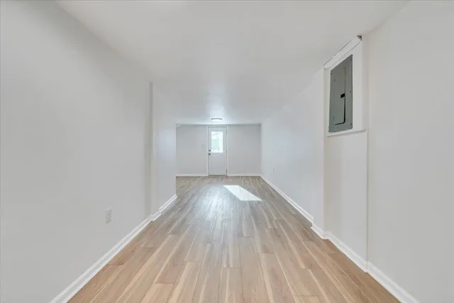 a view of empty room with wooden floor