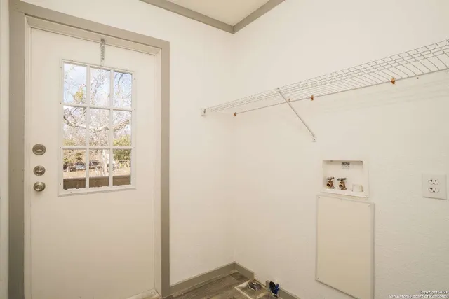 a view of a closet area with wooden floor