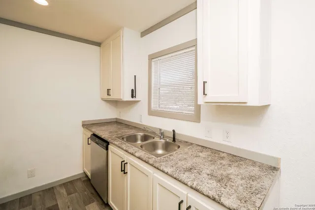 a kitchen with a sink window and cabinets