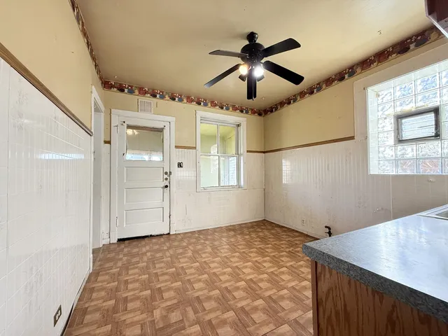 en empty room with ceiling fan and wooden floor
