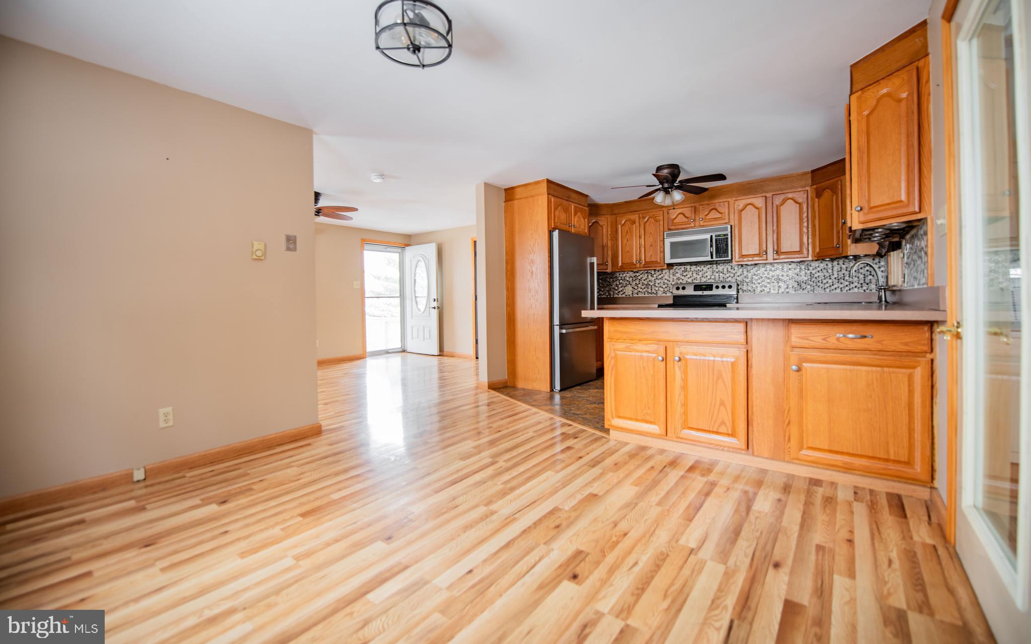 507 Grape Street Lock Haven, PA 17745 - Photo 4 of 26 a kitchen with stainless steel appliances granite countertop a sink stove and wooden floor
