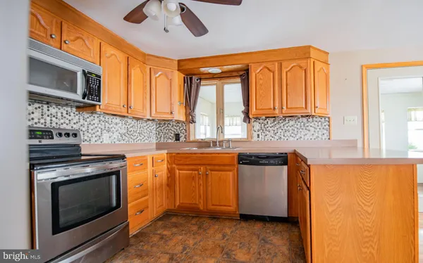 a kitchen with stainless steel appliances granite countertop wooden cabinets and a stove top oven