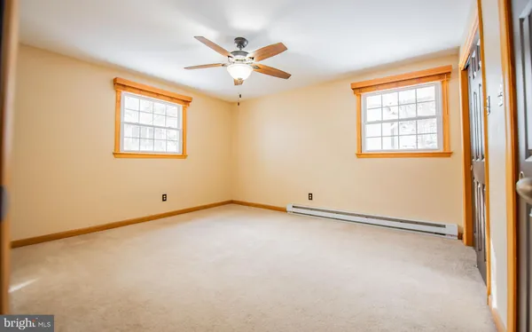 an empty room with windows and fan