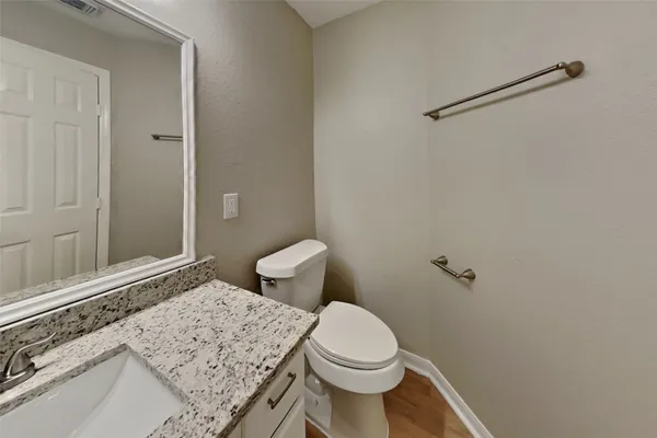 a bathroom with a granite countertop sink a toilet and shower