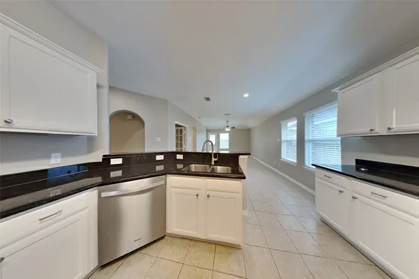 a kitchen with granite countertop a sink and cabinets