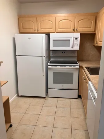 a white refrigerator freezer and a stove sitting inside of a kitchen