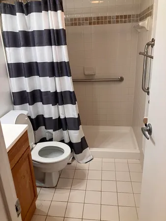 a bathroom with a sink a toilet a mirror a lamp and shower