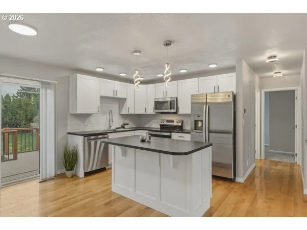 a kitchen with stainless steel appliances granite countertop a sink a stove a refrigerator and a sink