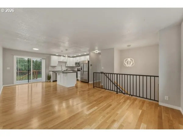 a view of a living room and kitchen with furniture wooden floor and window