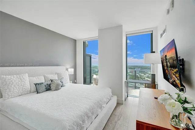 a bedroom with a bed and a flat screen tv