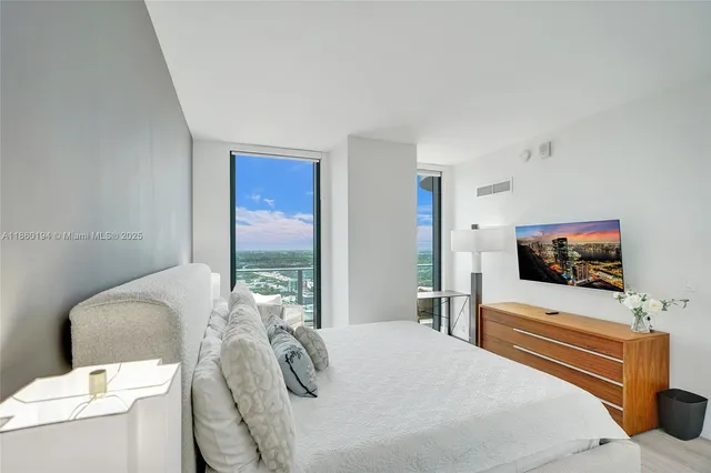 a bedroom with a bed and a flat screen tv