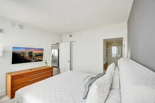 a bedroom with a bed and a flat screen tv