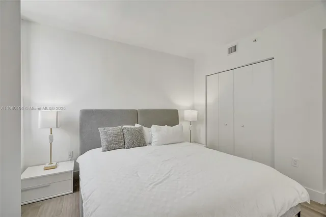 a bedroom with a bed and a night stand