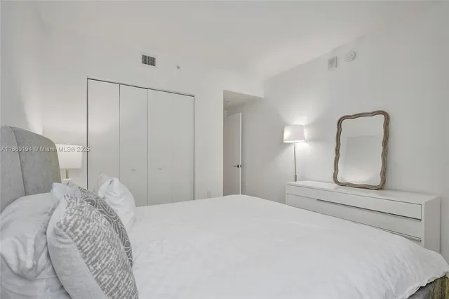 a bedroom with a large bed and a mirror