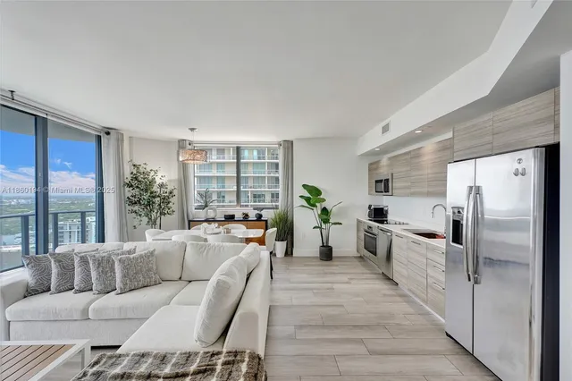 a living room with furniture large windows and wooden floor