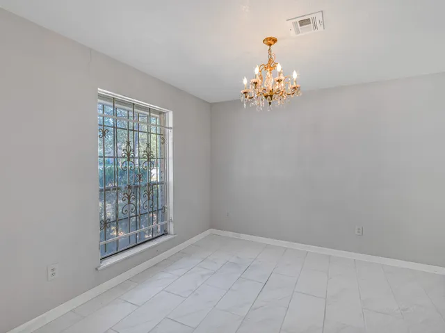 an empty room with windows and chandelier