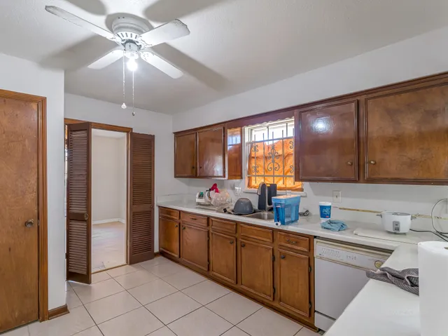 a kitchen with stainless steel appliances granite countertop a sink cabinets and wooden floor