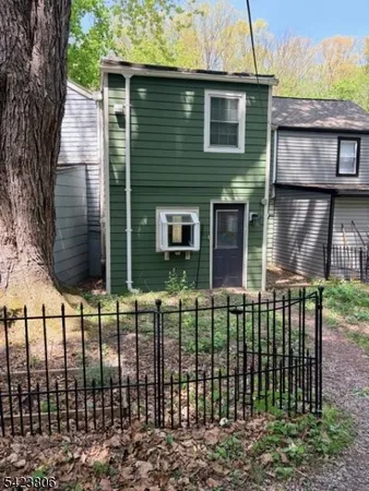 a view of a house with a small yard and wooden fence
