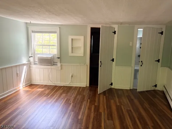 a view of a room with wooden floor and a window