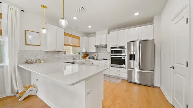 a kitchen with white cabinets and stainless steel appliances