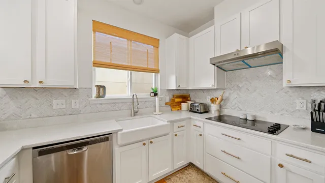 a kitchen with stainless steel appliances white cabinets and a window