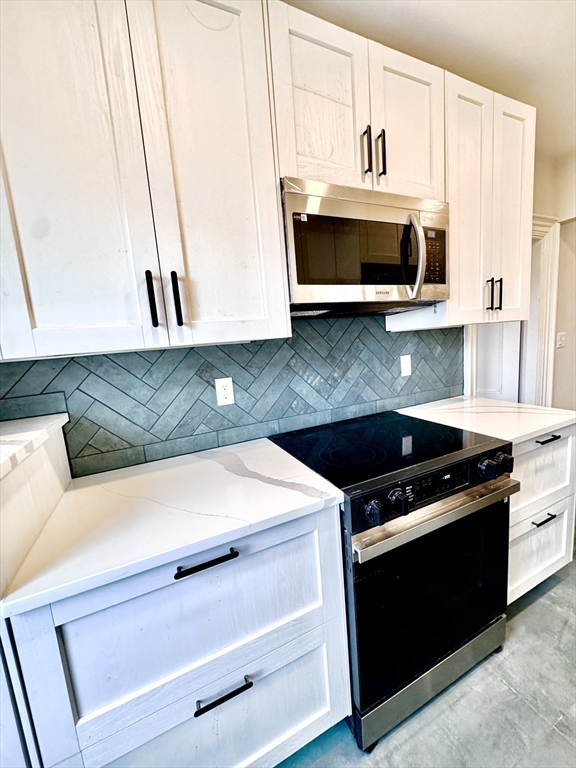 169 West Brookline Street, Unit PH Boston, MA 02118 - Photo 11 of 19 a kitchen with granite countertop white cabinets and stainless steel appliances