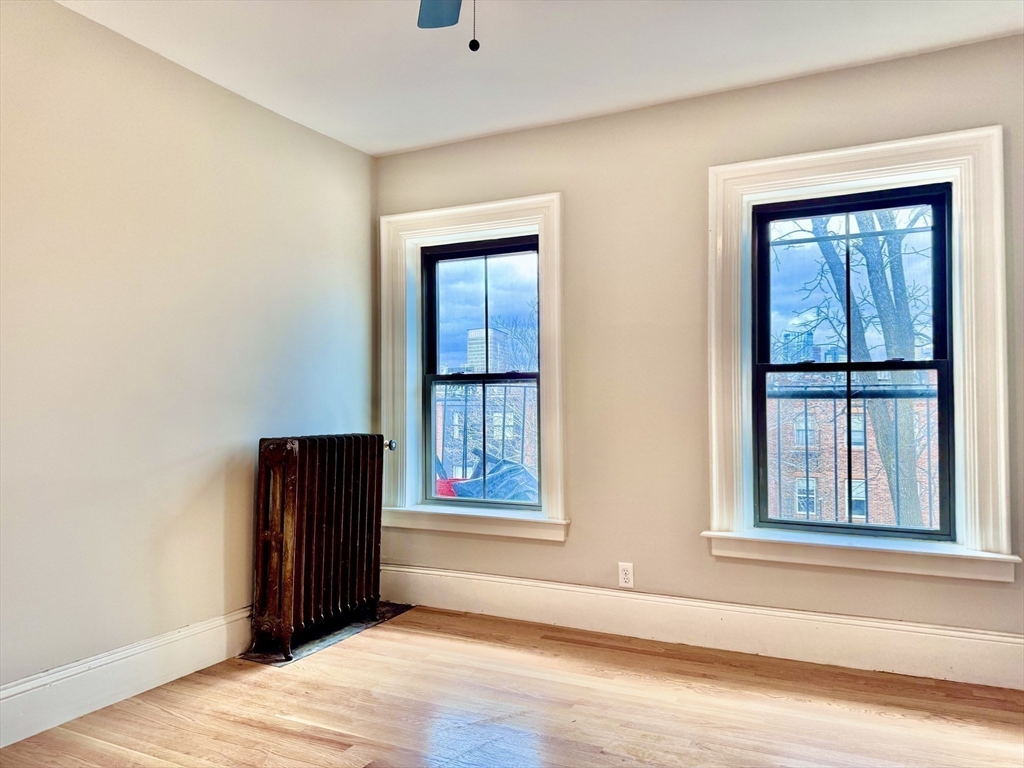 169 West Brookline Street, Unit PH Boston, MA 02118 - Photo 18 of 19 an empty room with wooden floor and windows
