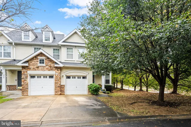 a view of a white house with large windows and a tree