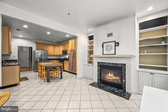 a living room with furniture a fireplace and kitchen view