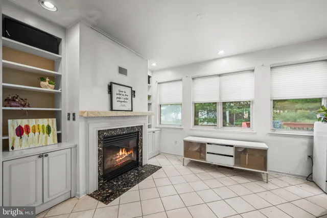 a living room with furniture a fireplace and a large window