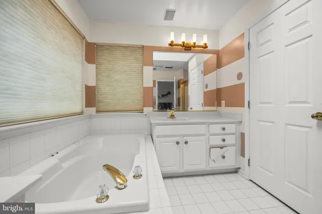 a bathroom with a bathtub sink and mirror