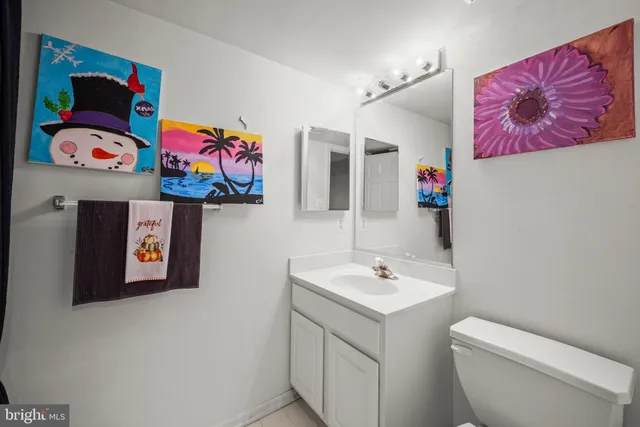 a bathroom with a sink a mirror and painting on the wall