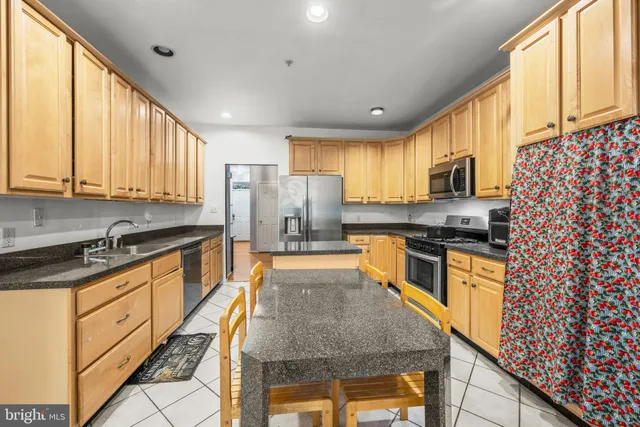 a large kitchen with stainless steel appliances granite countertop a stove a sink dishwasher and a refrigerator