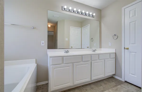 a bathroom with a double vanity sink and a mirror