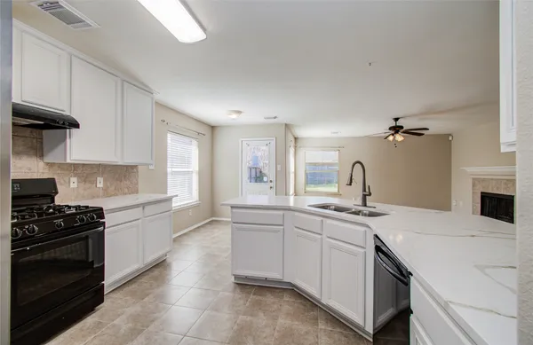a kitchen with a sink and white cabinets