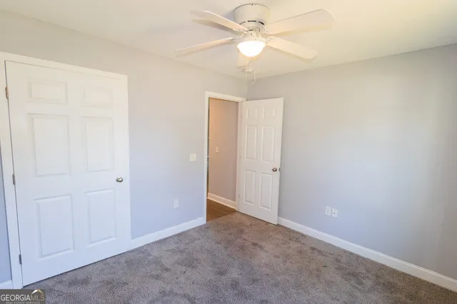 an empty room with a ceiling fan and a window