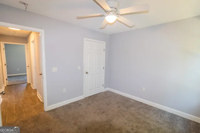 an empty room with a ceiling fan and a window