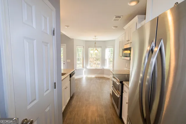 a view of a hallway with wooden floor and staircase