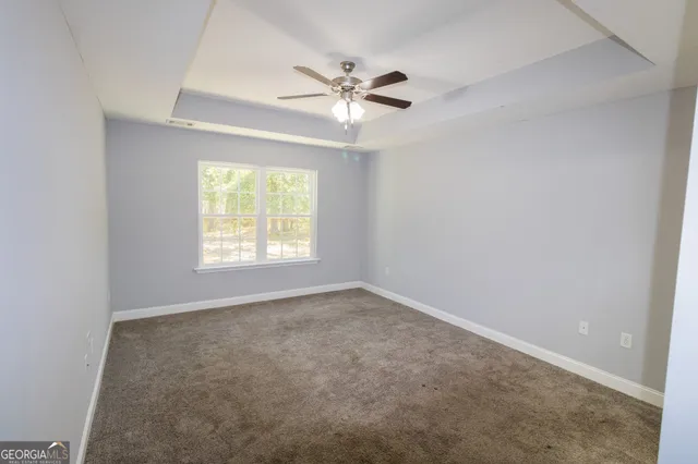 an empty room with window and ceiling fan