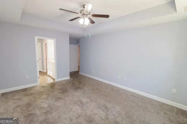 an empty room with a ceiling fan and a window