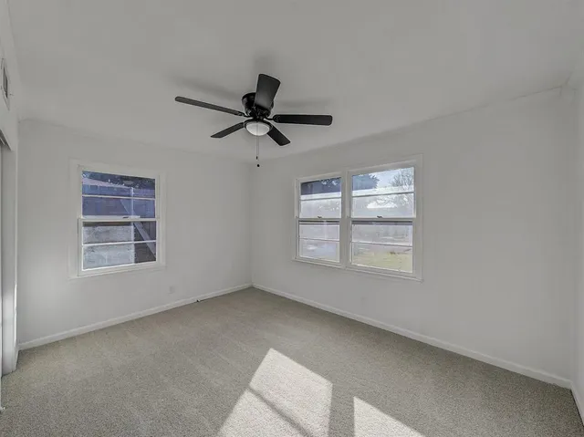 a view of a livingroom with a ceiling fan and window