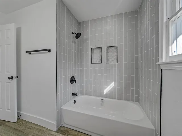 a bathroom with a tub shower and vanity