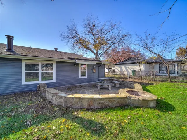 a view of a house with backyard and sitting area